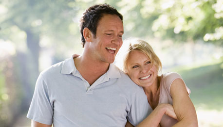 smiling adult couple walking on a trail